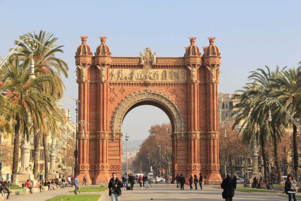 Arc de Triomf with people and palm trees on a sunny day