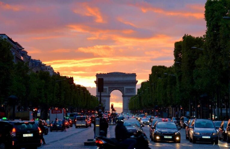 The Arc de Triomphe at sunset with traffic on Champs-Élysées