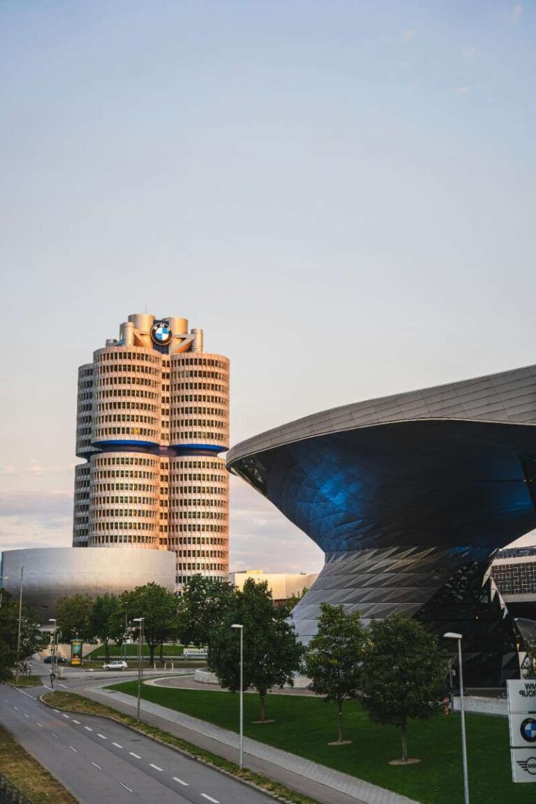 Futuristic architecture of the BMW Museum next to a high-rise BMW tower in Munich