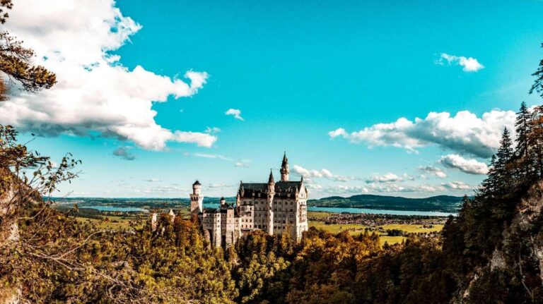 Neuschwanstein Castle in Munich amid lush greenery and rolling hills