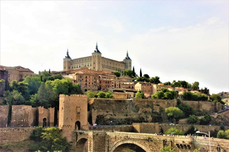 Alcázar (castle) of Toledo atop the city with stone walls and a river bridge