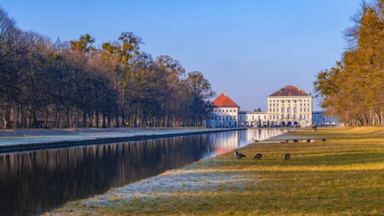 Nymphenburg Palace reflecting in a pond at dusk in Munich