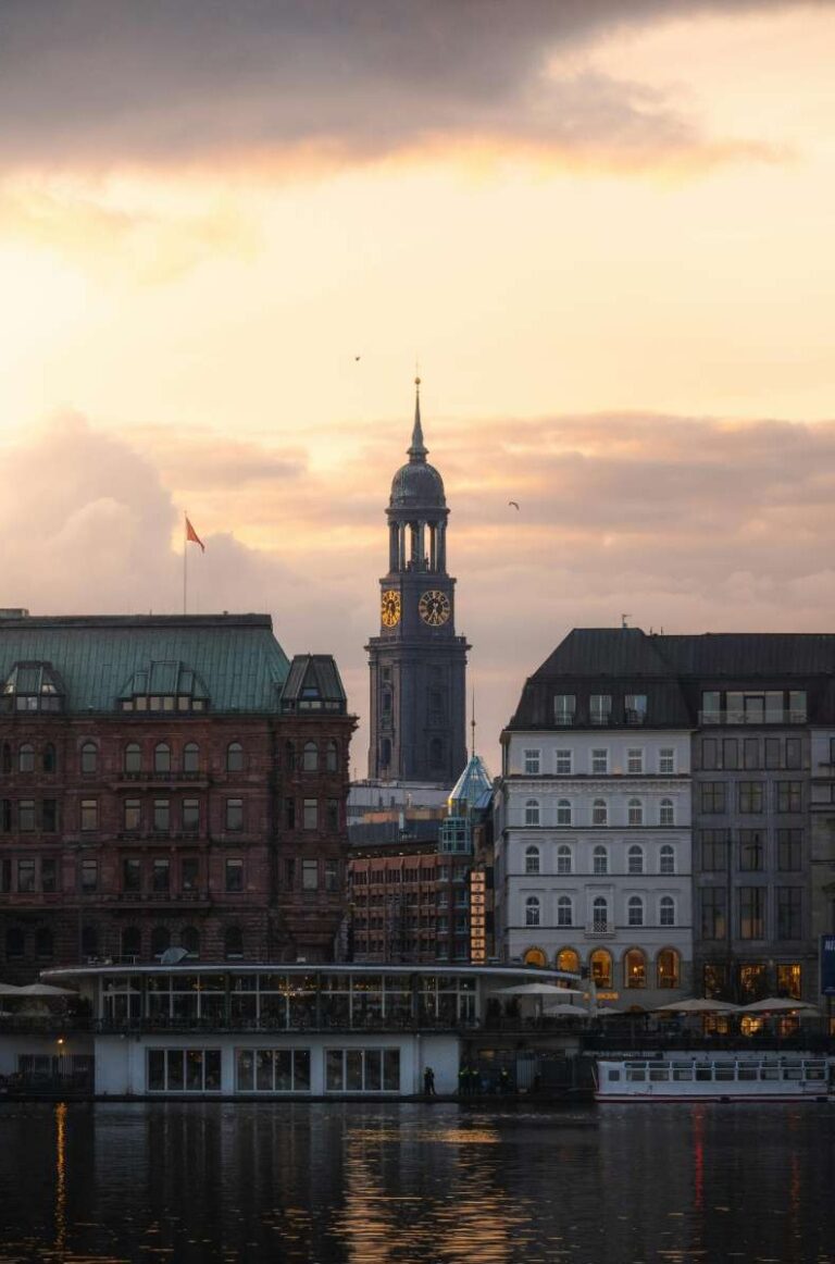 Historic Hamburg church tower at sunset with a warm glow on buildings