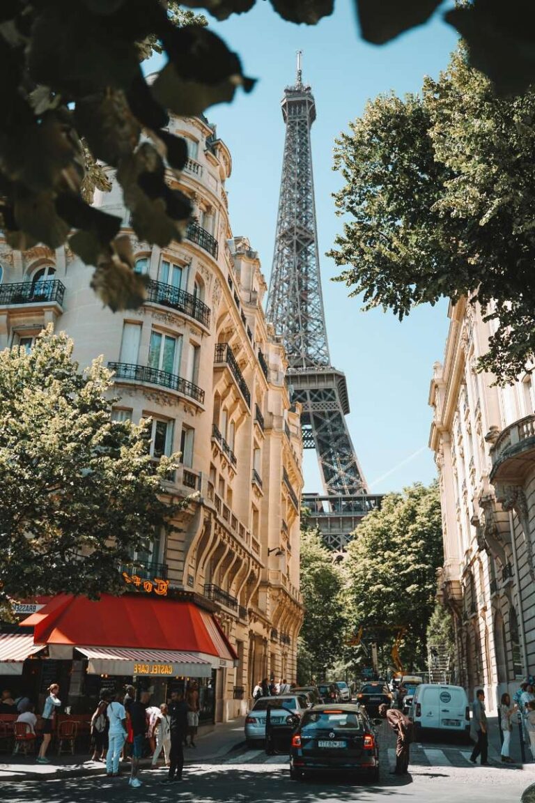 View of the Eiffel Tower from a tree-lined Parisian street