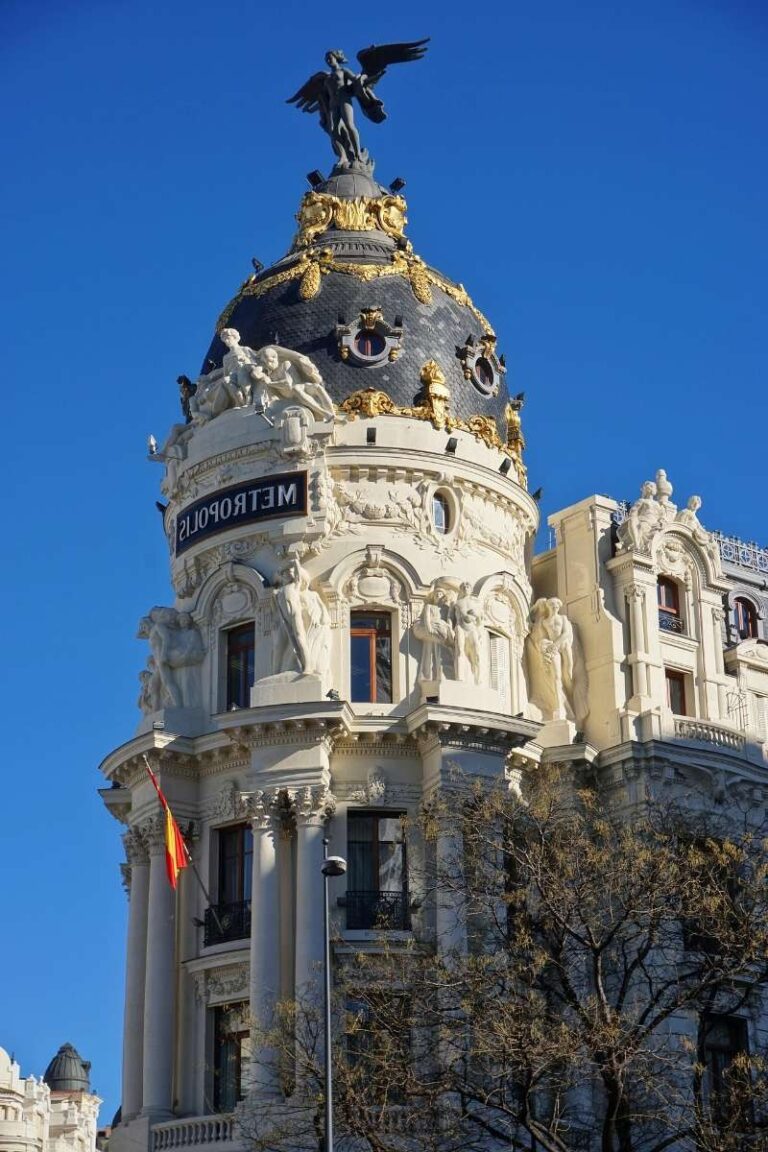 Metropolis Building in Madrid with statues and a dome