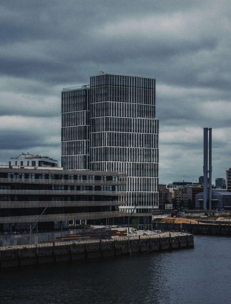 Modern glass office building in Hamburg under an overcast sky