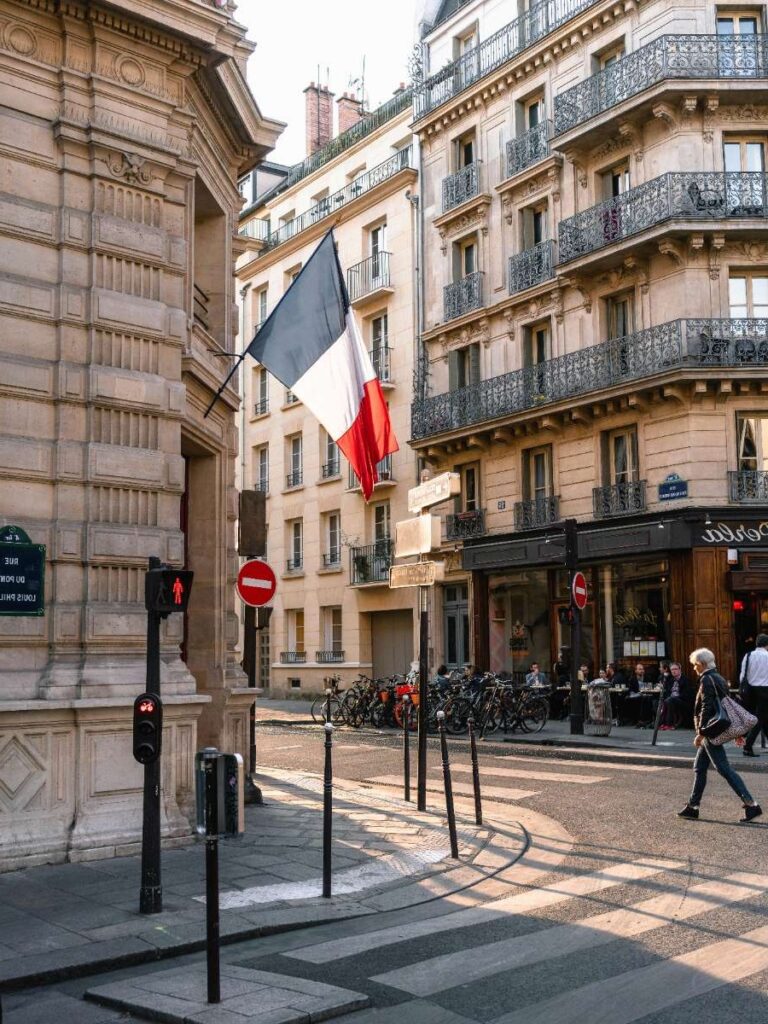 Street in Paris with French flag and classic architecture