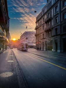 Tram on a city street in Zurich during sunset with historic buildings