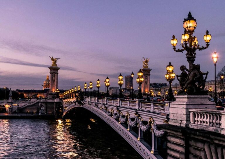 Evening view of the ornate Pont Alexandre III bridge in Paris with street lamps