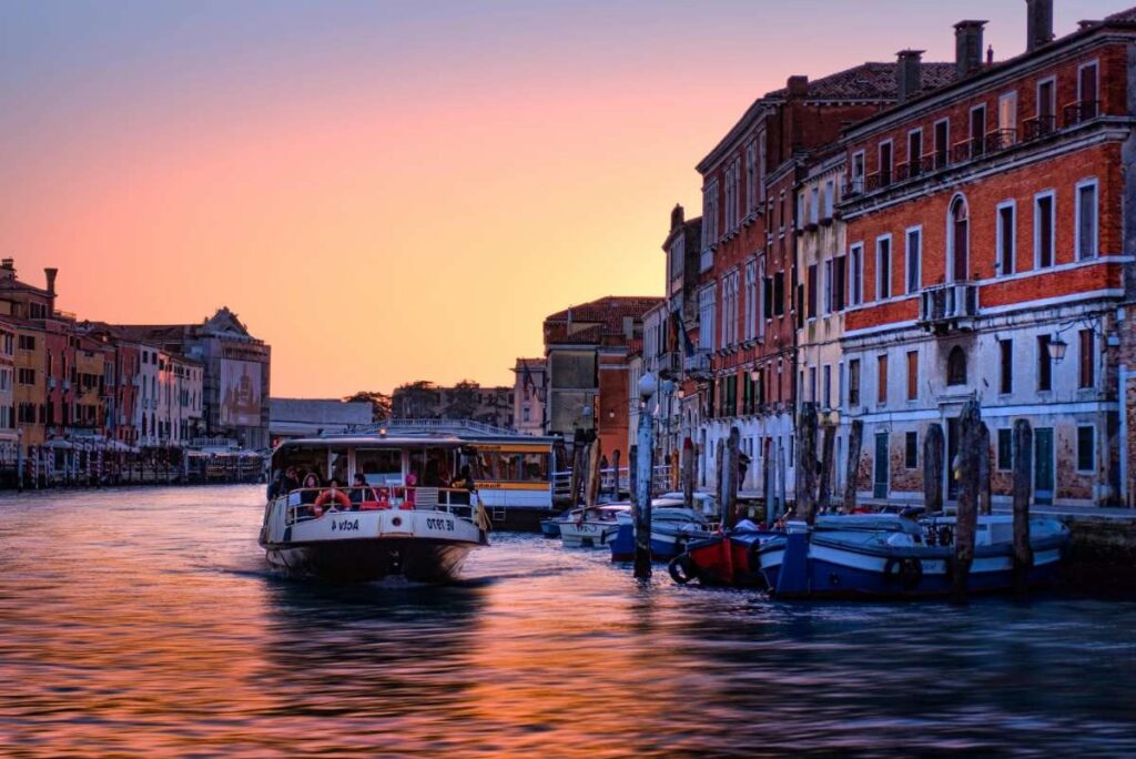 Boat cruising along the Grand Canal at sunset in Venice