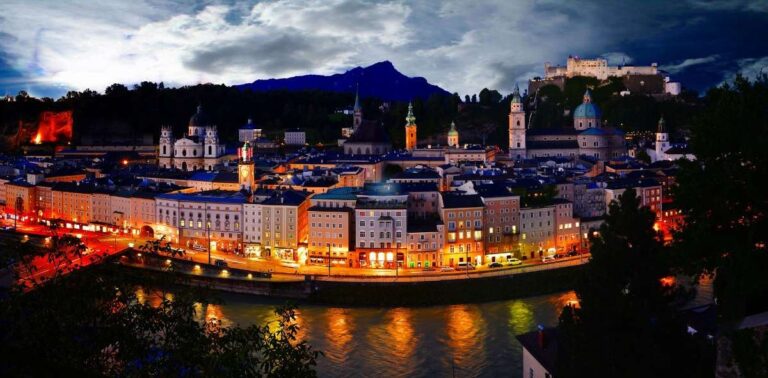 A night view of Salzburg's illuminated cityscape by the river