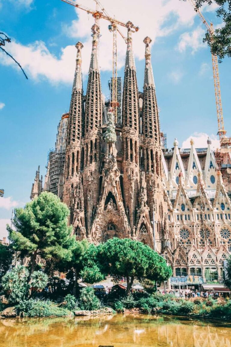 Sagrada Familia with cranes and lush greenery