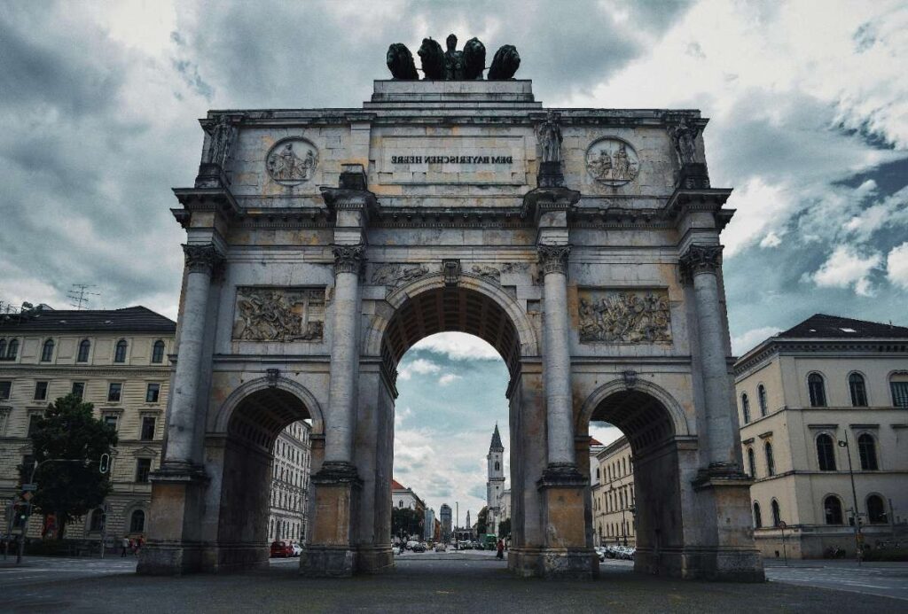 Siegestor or Victory Gate in Munich with detailed stone carvings and cloudy skies