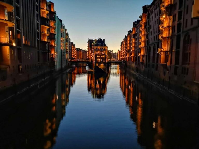 Speicherstadt in Hamburg lit up at night with reflections on the canal water