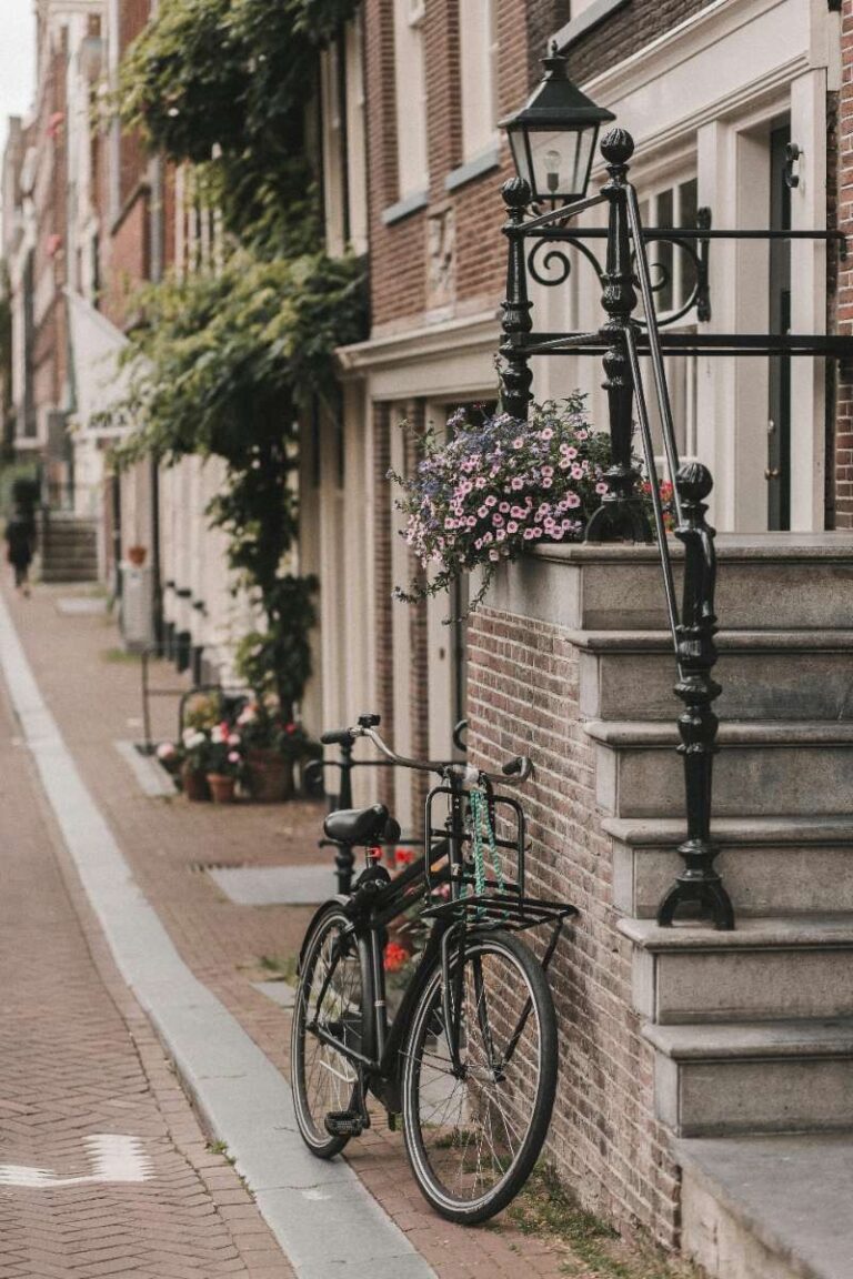 A bicycle leaning against a house on a narrow Amsterdam street