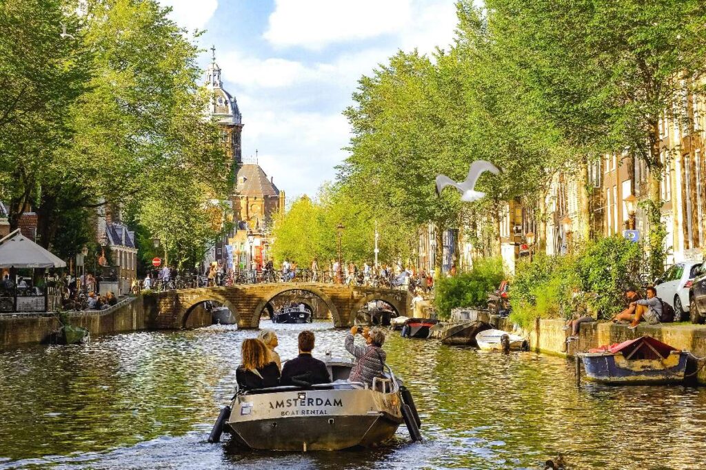 typical boat in Amsterdam floating through a gracht o canal in Netherlands