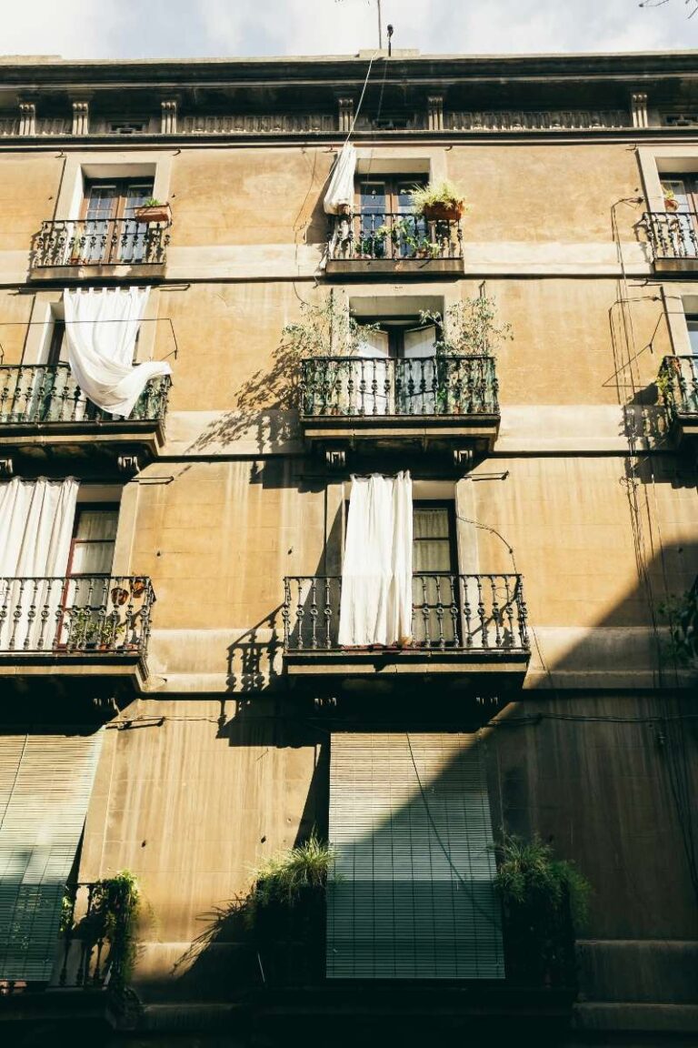 Historic Barcelona building with wrought-iron balconies and draped curtains