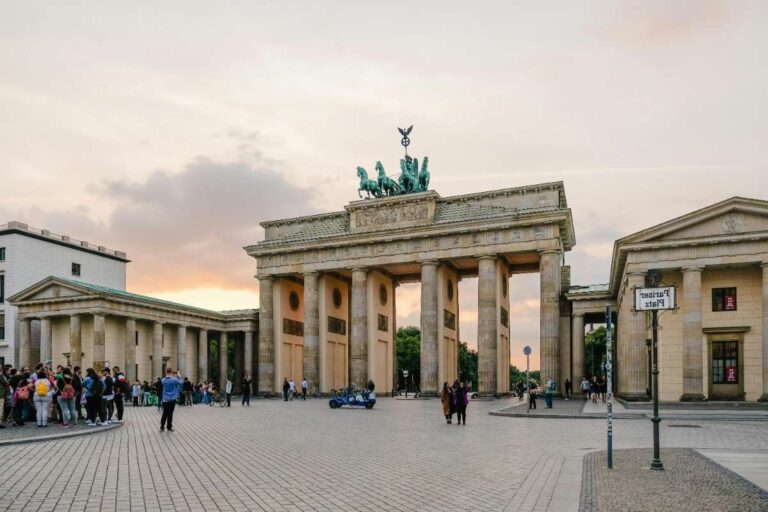 The Brandenburg Gate at dusk with a crowd gathered around