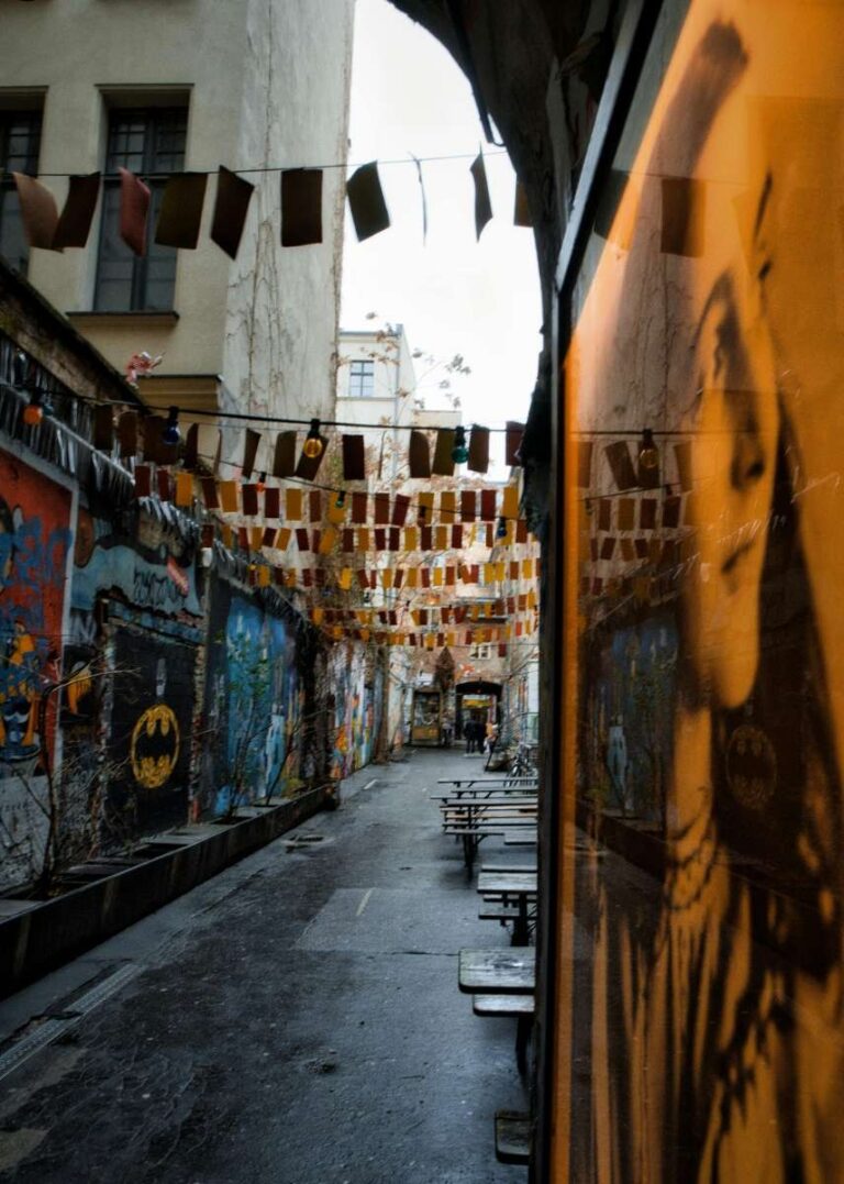 Graffiti-lined alleyway in Berlin with colorful lights and decorations