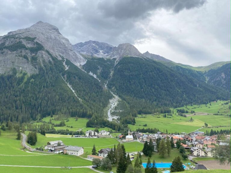 Lush green valley with mountains and a quaint village