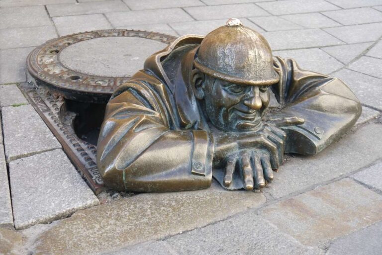 Bronze statue of a man emerging from a manhole in Bratislava