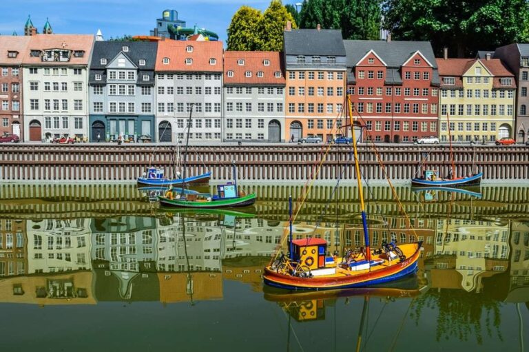 Colorful miniature houses with small boats reflecting in the water