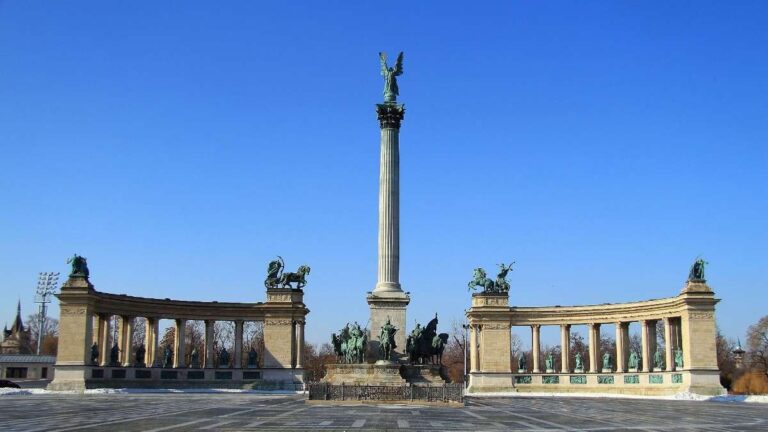 Panoramic view of Heroes' Square with statues under a clear blue sky