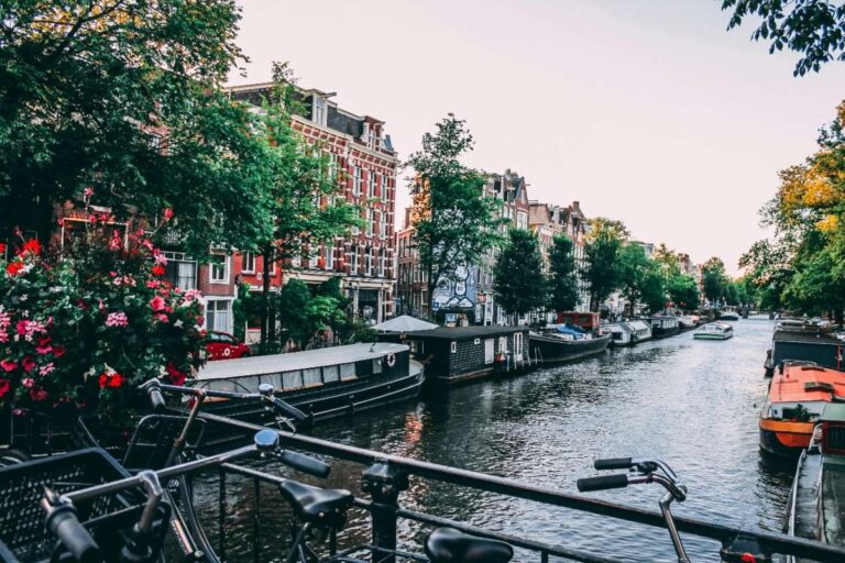 Bicycles and houseboats line a scenic canal in Amsterdam