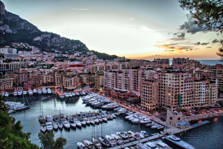 Sunset view of Cannes harbor filled with yachts and buildings