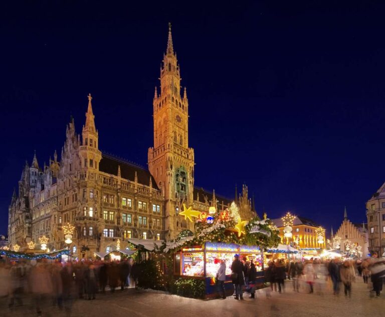 Christmas market in Munich at Marien square with the tall town hall clock tower at night