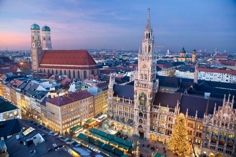 Panoramic view of Munich with a Christmas market and the cathedral in the evening