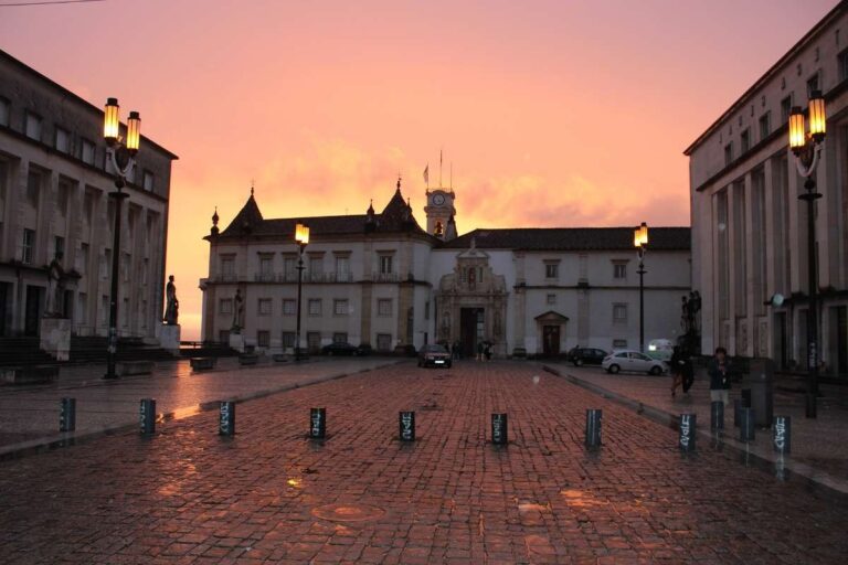 Coimbra square at sunset with historic architecture and streetlights