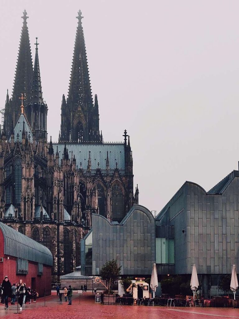 The majestic Cologne Cathedral under a moody evening sky by the Rhine River