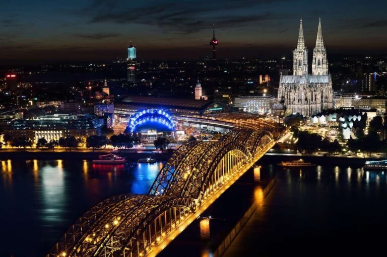 Cologne Cathedral and Hohenzollern Bridge illuminated at dusk