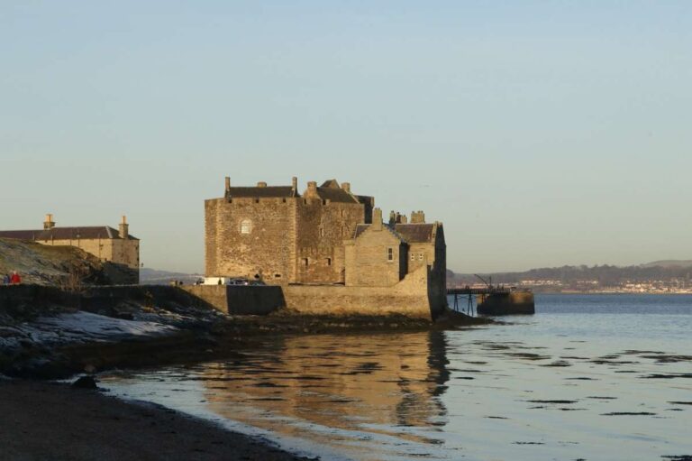 A historic stone castle by the sea under a clear blue sky