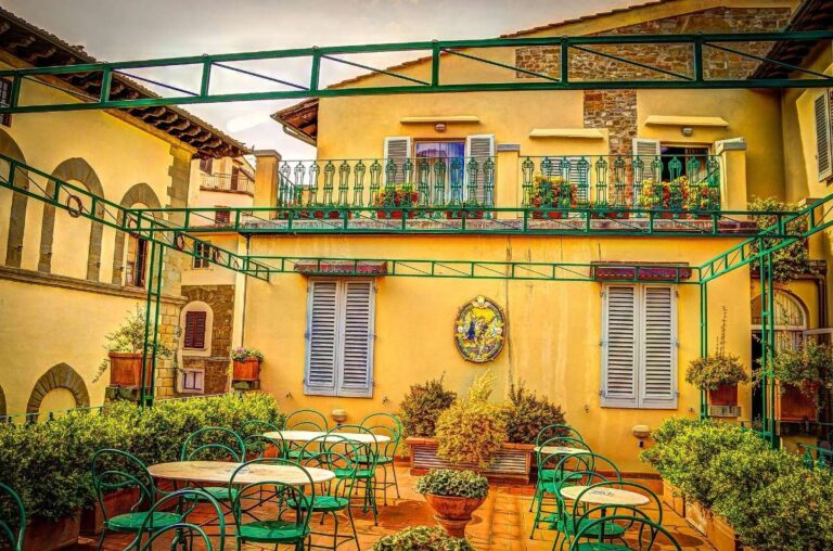 A charming outdoor terrace with green chairs and potted plants in Florence