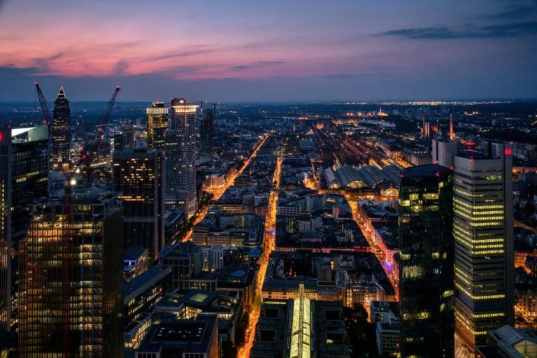 Frankfurt skyline at dusk with skyscrapers and illuminated streets below