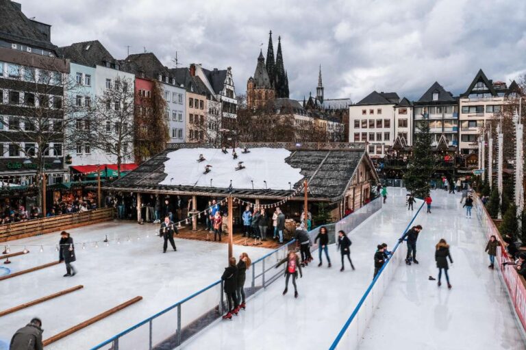 Outdoor ice skating rink surrounded by people at a Christmas market in Cologne