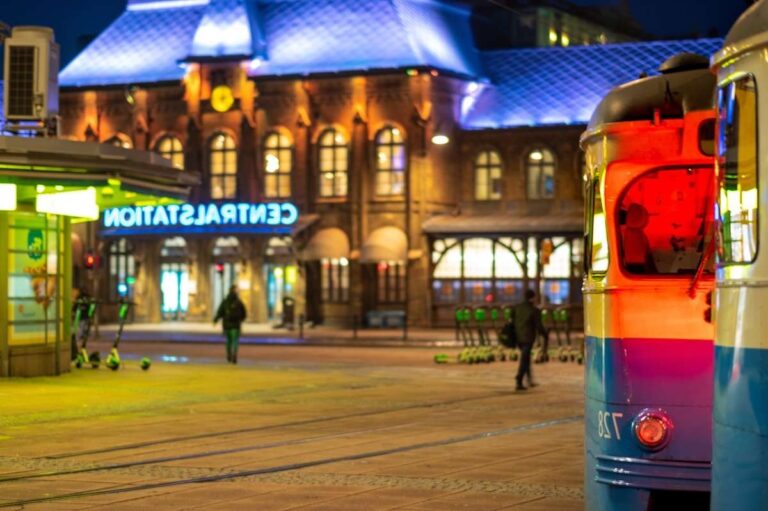 Gothenburg Central Station lit up at night with a nearby tram