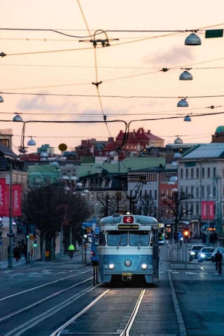 A blue tram traveling through the city center of Gothenburg