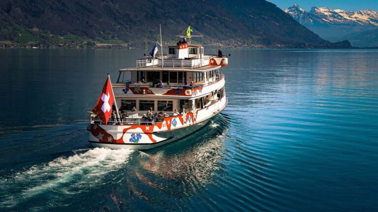 Boat with Swiss flag on a clear lake surrounded by mountains