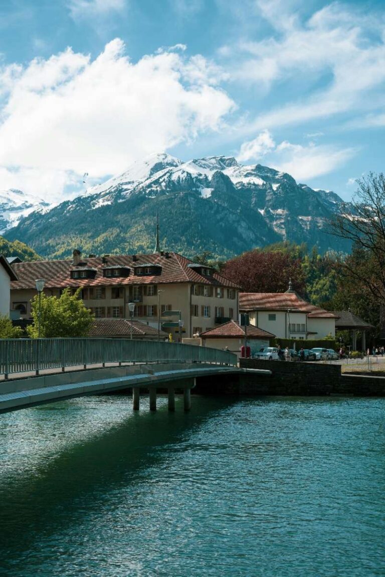 Bridge over water with snow-capped mountains in the background