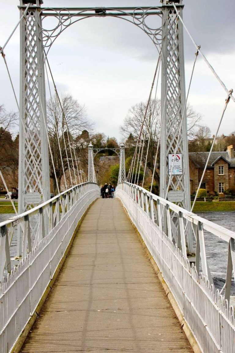 A footbridge in Inverness with metal arches over a river