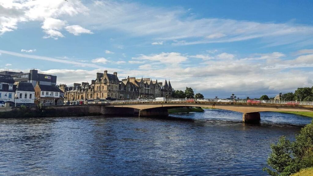 A bridge over a river in Inverness with historic buildings