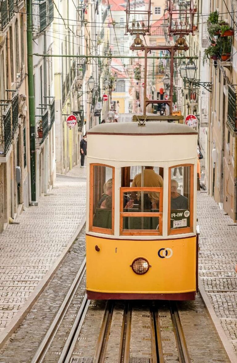 Iconic yellow tram in Lisbon climbing a steep street