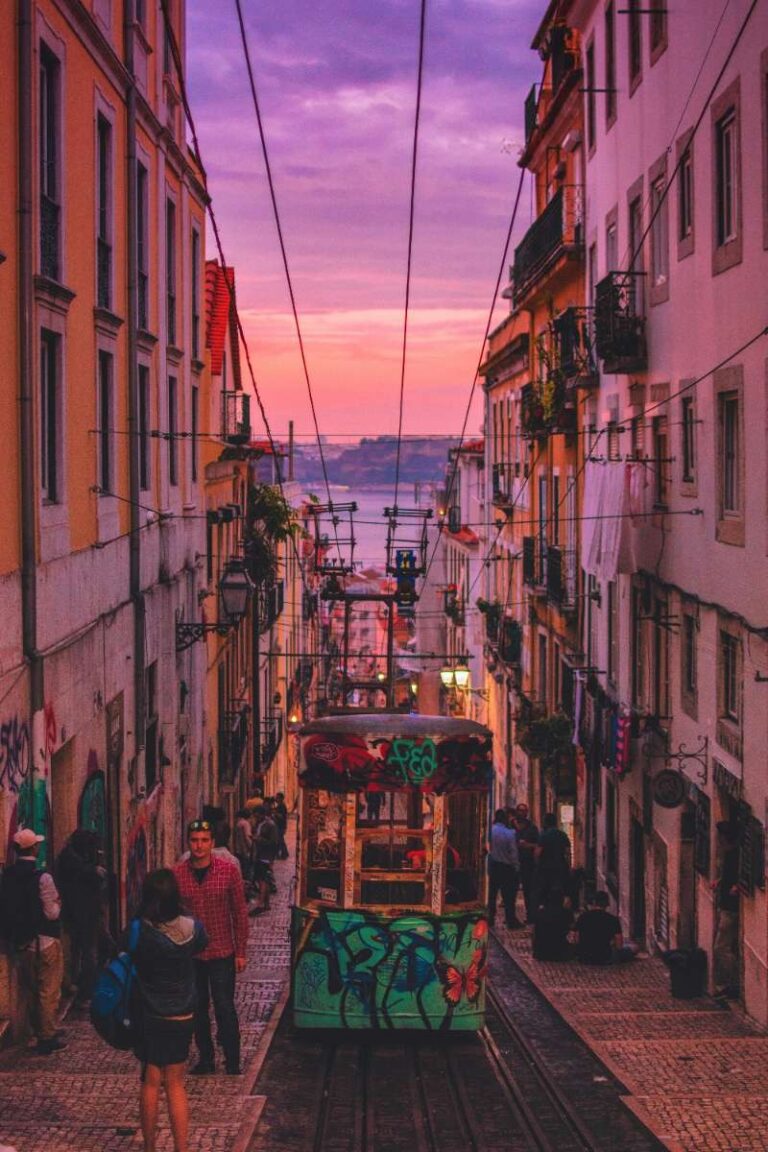 Lisbon street with tram and sunset over the river