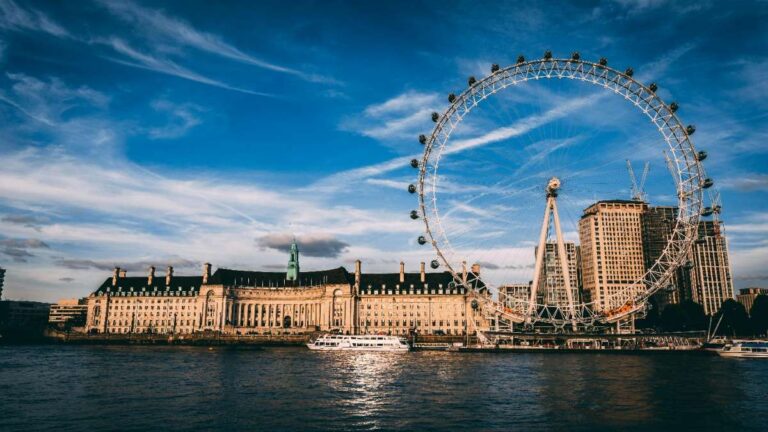 The iconic London Eye ferris wheel beside the Thames River at sunset