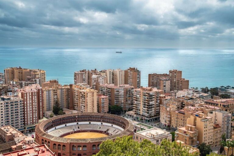 Aerial view of Malaga with a bullring, skyscrapers, and the Mediterranean Sea