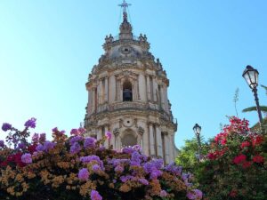 Modica Cathedral with vibrant flower garden in the foreground