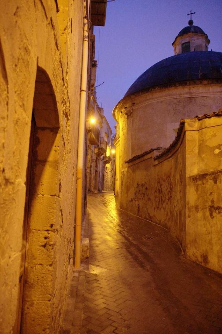 Narrow street lined with old stone buildings in Modica